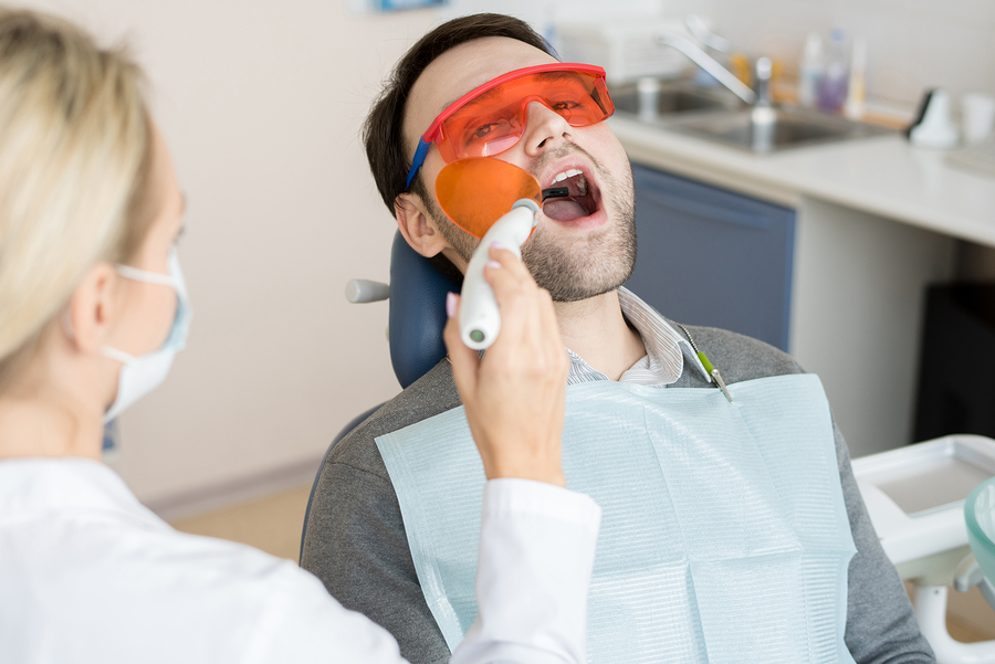 Portrait Of Mature Man Sitting In Dental Chair With Mouth Open W